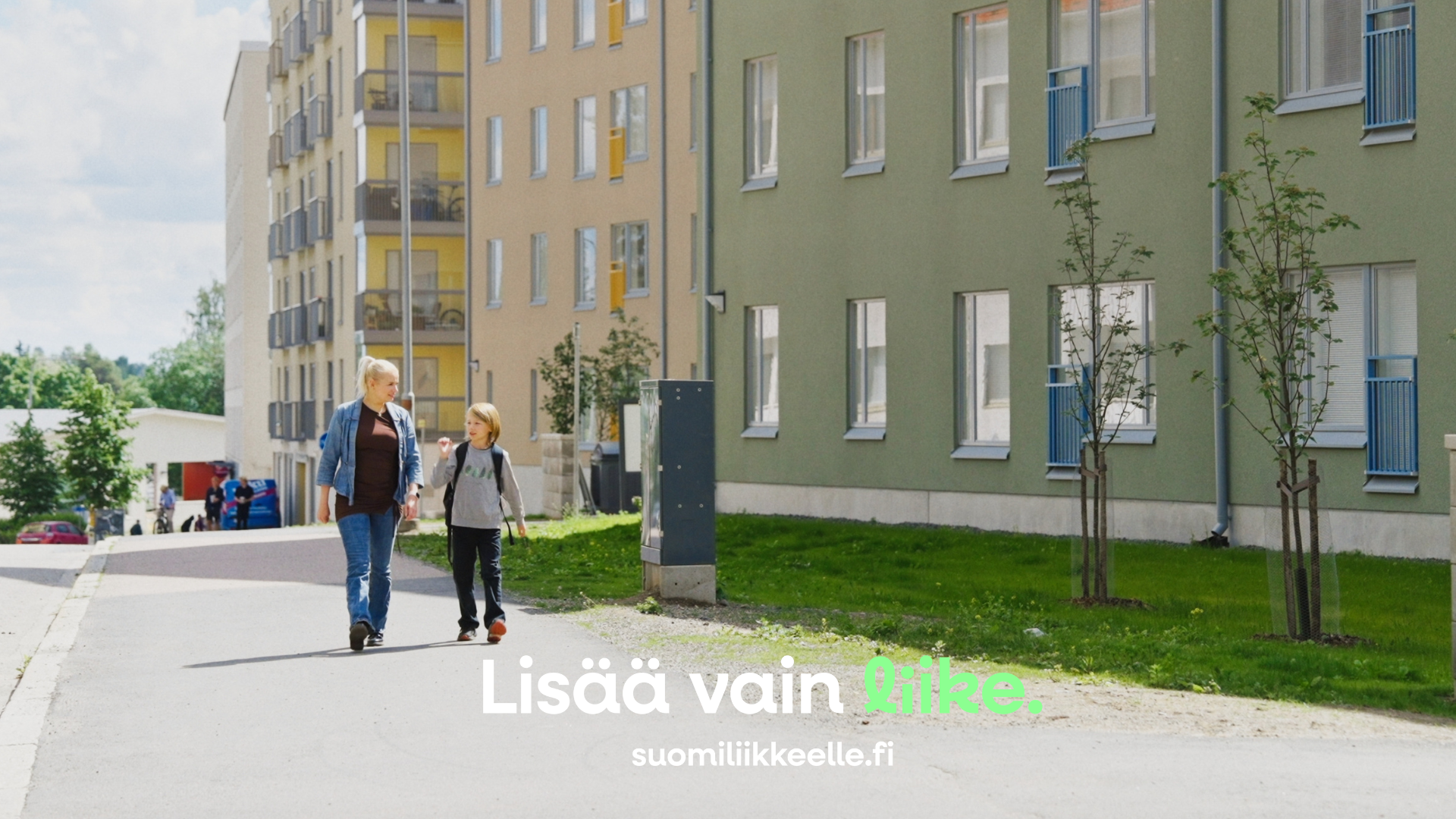 Huoltaja ja koululainen kävelevät yhdessä kouluun.
